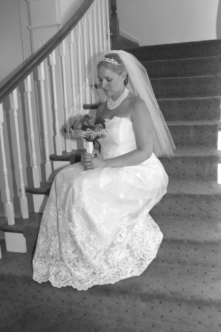 Bride sitting on steps wearing custom wedding gown