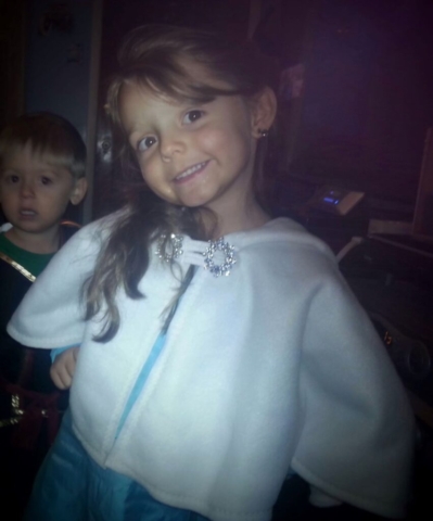 young girl wearing a white fleece capelet.