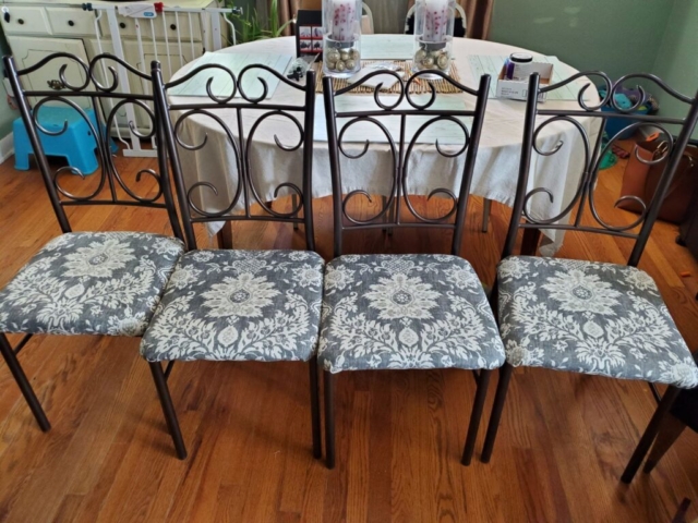 Four dining room chairs that have recovered seat cushions