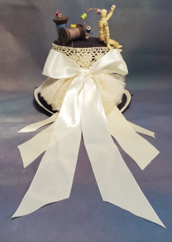 back view of woman's steam punk hat with long off-white colored ribbons