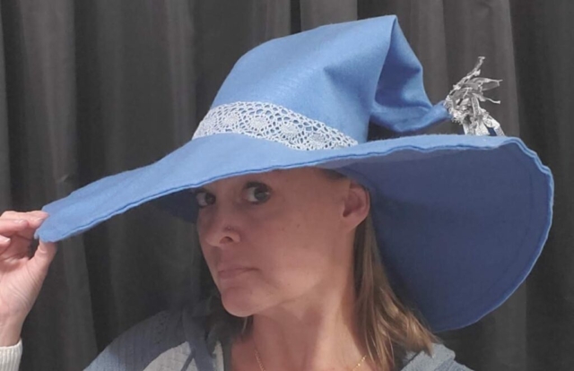 woman wearing a light blue felt witches hat