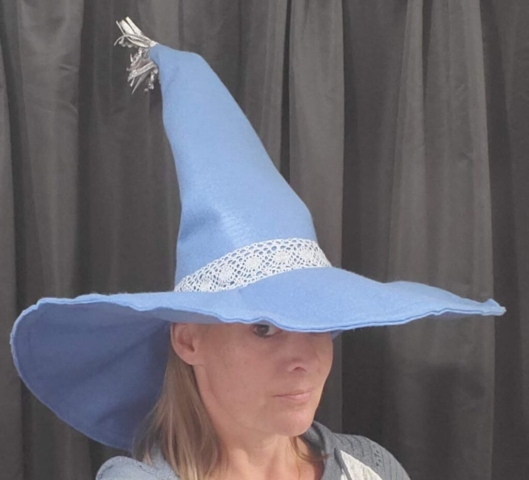 Second view of woman wearing a blue felt witches hat