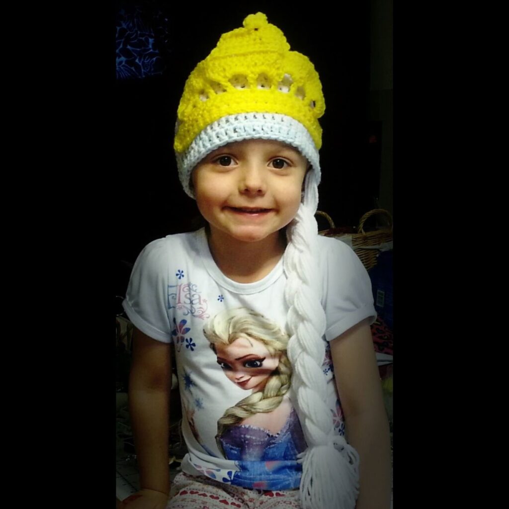 Young girl wearing a crocheted Elsa Hat