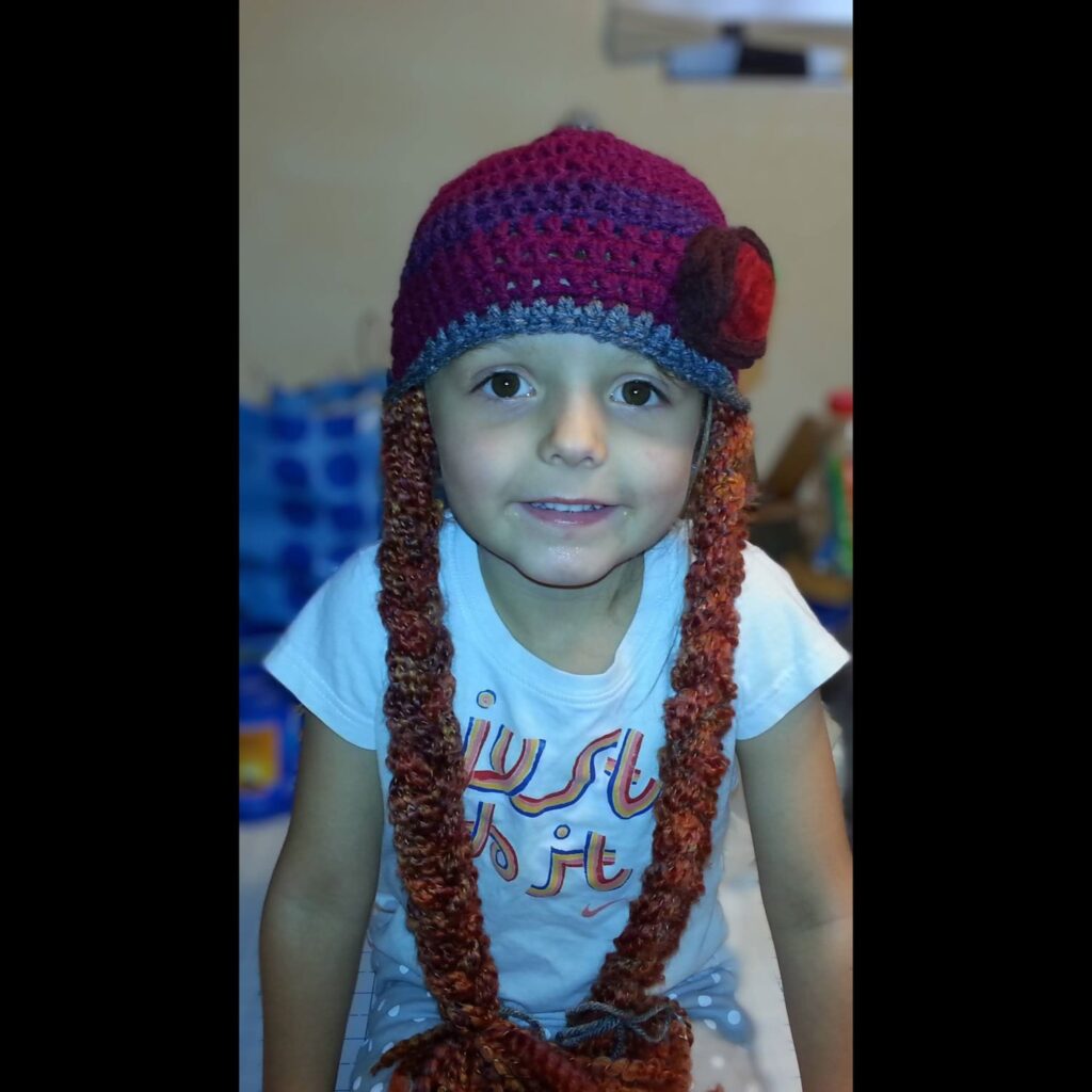 Young girl wearing a crocheted anna hat