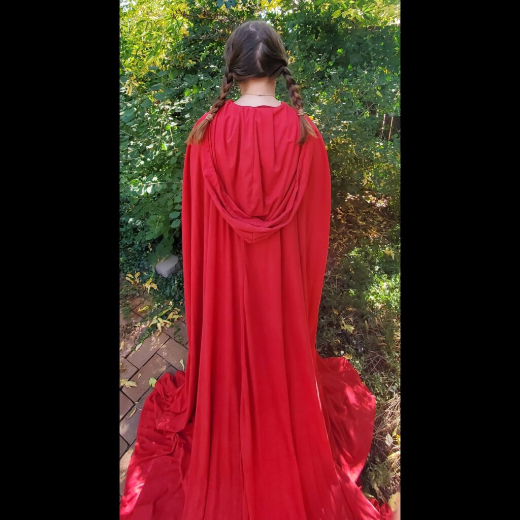 Girl wearing long red cloak