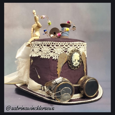 Front view of woman's sewing themed steampunk top hat